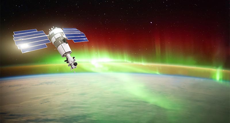 Satellite in space over earth with aurora